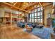 Spacious living room with log beams, hardwood floors, large windows and comfortable seating area at 15958 Shadow Mountain Ranch Rd, Larkspur, CO 80118