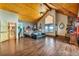 Spacious main bedroom boasting wood ceiling, stone fireplace, and natural light from the large windows at 15958 Shadow Mountain Ranch Rd, Larkspur, CO 80118
