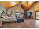 Comfortable main bedroom featuring vaulted ceilings, a fireplace, and views of the surrounding landscape at 15958 Shadow Mountain Ranch Rd, Larkspur, CO 80118