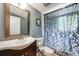 Bathroom with a framed mirror, floral shower curtain, and white sink at 3278 S Forest St, Denver, CO 80222