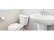 Compact bathroom with a white toilet and sink, showcasing a clean and simple design at 11142 Bella Vita Dr, Broomfield, CO 80020