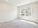 A bright carpeted bedroom features a window offering neighborhood views and blank walls at 11142 Bella Vita Dr, Broomfield, CO 80020