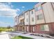 Inviting townhome with brick accents, covered entrances, and well-maintained landscaping along a pedestrian walkway at 11142 Bella Vita Dr, Broomfield, CO 80020