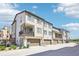 Modern townhome showcasing neutral siding, a balcony, and a one-car garage, under a bright blue sky at 11142 Bella Vita Dr, Broomfield, CO 80020