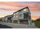 Charming townhome exterior with gray siding, a private balcony, and a one-car garage, set against a vibrant sunset sky at 11142 Bella Vita Dr, Broomfield, CO 80020