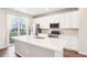 Bright kitchen featuring stainless steel appliances, white cabinetry, an island, and a view of the surrounding neighborhood at 11142 Bella Vita Dr, Broomfield, CO 80020