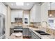 A modern kitchen features granite counters, a stainless steel oven, a window, and gray and white cabinets at 543 N Marion St, Denver, CO 80218