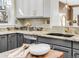 An open kitchen featuring granite counters, white subway tile, stainless appliances, and updated gray cabinets at 543 N Marion St, Denver, CO 80218