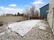 Large backyard with a rock perimeter, small patio, and partial snow cover at 10699 Butte Dr, Longmont, CO 80504