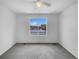 A cozy bedroom with neutral carpet, a ceiling fan, and a large window at 10699 Butte Dr, Longmont, CO 80504