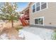 Exterior view of a house with a wooden staircase leading to a covered balcony, complemented by a spacious yard at 3659 Makley Cir, Castle Rock, CO 80104