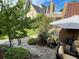 Cozy backyard with stone patio, lush landscaping, and mature trees, perfect for outdoor relaxation and entertainment at 615 N Williams St, Denver, CO 80218