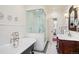 Bathroom featuring subway tile, a soaking tub, glass enclosed shower, and custom vanity at 615 N Williams St, Denver, CO 80218
