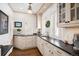 Bright kitchen with custom white cabinetry, black countertops, and warm hardwood floors at 615 N Williams St, Denver, CO 80218