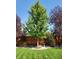 Landscaped backyard featuring a vibrant green tree, lush lawn, wood fence and small bird bath at 20040 E Doane Dr, Aurora, CO 80013