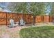 Cozy backyard with a brick patio, two white Adirondack chairs, and a lush green lawn at 20040 E Doane Dr, Aurora, CO 80013