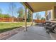 Inviting backyard with a covered patio, stone walkway, seating area, lush lawn, and wood fence at 20040 E Doane Dr, Aurora, CO 80013