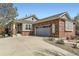 Inviting brick home featuring a spacious driveway and a two-car garage, set under a clear blue sky at 20040 E Doane Dr, Aurora, CO 80013