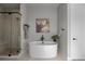 Bright bathroom featuring a luxurious soaking tub, frameless shower and herringbone floors at 10869 Bluffside Dr, Lone Tree, CO 80124