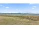 Expansive green landscape with a distant mountain view under a clear sky, showcasing outdoor living at 10869 Bluffside Dr, Lone Tree, CO 80124