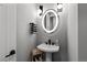 Chic powder room featuring a pedestal sink, modern lighting, and stylish mirror at 10869 Bluffside Dr, Lone Tree, CO 80124