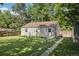 Backyard featuring a green lawn, mature trees, and a view of the rear of the home at 1975 Cody St, Lakewood, CO 80215