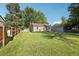 Exterior shot of backyard featuring healthy green lawn, mature trees, and detached garage at 1975 Cody St, Lakewood, CO 80215