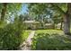 Charming green home with stone accents, complemented by lush lawn and trees at 1975 Cody St, Lakewood, CO 80215