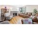 Comfortable living room featuring a brick fireplace, hardwood floors, and natural lighting at 1975 Cody St, Lakewood, CO 80215