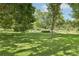 Expansive green lawn surrounded by mature trees, creating a serene park-like setting at 1975 Cody St, Lakewood, CO 80215