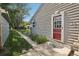Charming home exterior with a red back door, tidy landscaping, and lush green lawn at 1975 Cody St, Lakewood, CO 80215