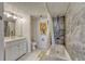 Well-lit bathroom features a shower-tub combo with tiled walls, a neutral vanity and fixtures at 701 Harlan St # E72, Lakewood, CO 80214