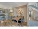 Dining room features hardwood floors, a table with seating for four, and a view into the kitchen at 701 Harlan St # E72, Lakewood, CO 80214