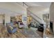 Bright living room features a fireplace, hardwood floors, stairs to second story and neutral paint colors at 701 Harlan St # E72, Lakewood, CO 80214
