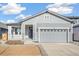 Gray exterior of charming ranch home with attached garage and front porch at 1547 Orchard St, Brighton, CO 80601