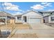 Two-car garage, front porch, and gray siding on a new construction home at 1547 Orchard St, Brighton, CO 80601