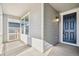 Inviting front porch with gray siding and a dark-colored front door at 1547 Orchard St, Brighton, CO 80601