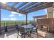Outdoor patio with a fireplace, dining set, and string lights under a pergola at 3734 Ridgeway St, Boulder, CO 80301