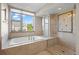 Elegant bathroom featuring a soaking tub and a glass-enclosed shower with stylish tile accents at 3734 Ridgeway St, Boulder, CO 80301