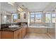 Bathroom with double sinks, tile floor, soaking tub, and natural light from large windows at 3734 Ridgeway St, Boulder, CO 80301