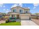 Charming two-story home showcasing a well-maintained lawn, inviting porch, and an attached two-car garage at 47300 Clover Ave, Bennett, CO 80102
