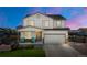 Charming two-story home showcasing a well-maintained lawn, inviting porch, and an attached two-car garage at 47300 Clover Ave, Bennett, CO 80102