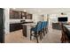 Spacious kitchen with granite counters, stainless appliances, an island with seating, and easy access to the living room at 47300 Clover Ave, Bennett, CO 80102