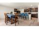 Open-concept kitchen and dining area with granite counters, island seating, and modern appliances at 47300 Clover Ave, Bennett, CO 80102