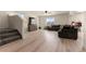Well lit living room with wood floors, a TV, staircase, and an inviting dark grey sectional couch at 47300 Clover Ave, Bennett, CO 80102