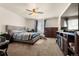Bedroom featuring plush carpeting, a ceiling fan, natural light, and a comfortable upholstered bed at 47300 Clover Ave, Bennett, CO 80102