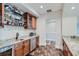 Stylish bar area with granite countertops, wine storage, and archway details at 2635 Spruce Meadows Dr, Broomfield, CO 80023