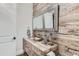 Stylish half bath featuring a wood accent wall, modern vanity, and decorative mirror at 2635 Spruce Meadows Dr, Broomfield, CO 80023