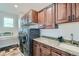 Well-equipped laundry room with modern washer and dryer, granite counters, and storage cabinets at 2635 Spruce Meadows Dr, Broomfield, CO 80023