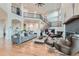 Open living room featuring a cozy fireplace, high ceilings, and plenty of natural light at 2635 Spruce Meadows Dr, Broomfield, CO 80023